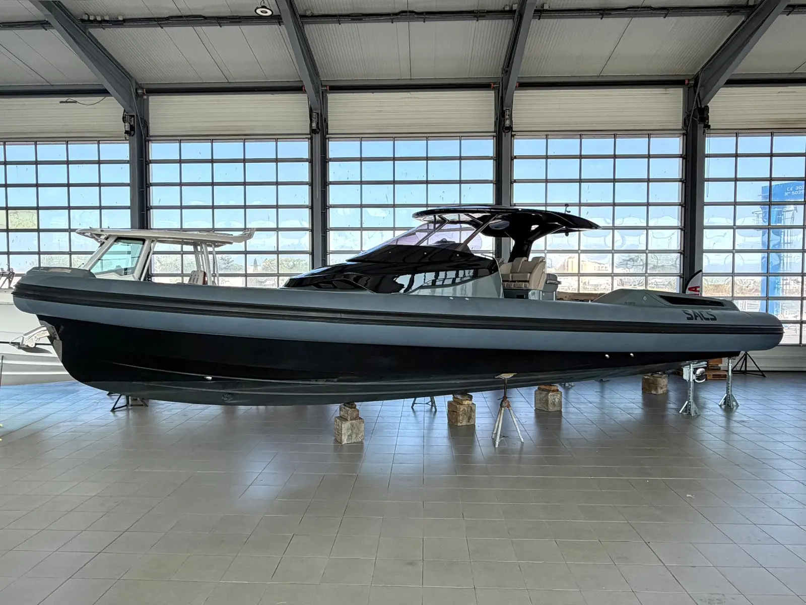 Sacs Strider 15 — Bateau semi-rigide noir et gris présenté de profil dans un hangar.