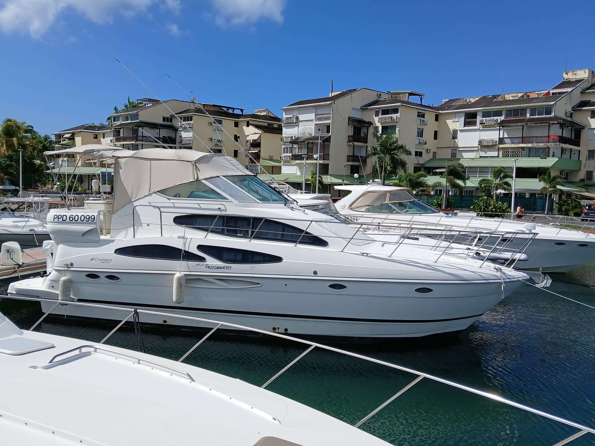 Cruisers Yachts 415 — Bateau à moteur blanc amarré dans une marina, vu de profil.
