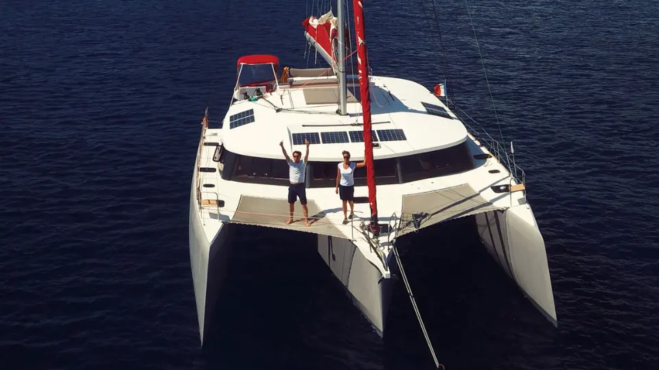 Neel Trimarans Neel 51 — Trimaran blanc vu de face sur l’eau, avec deux personnes sur le pont.