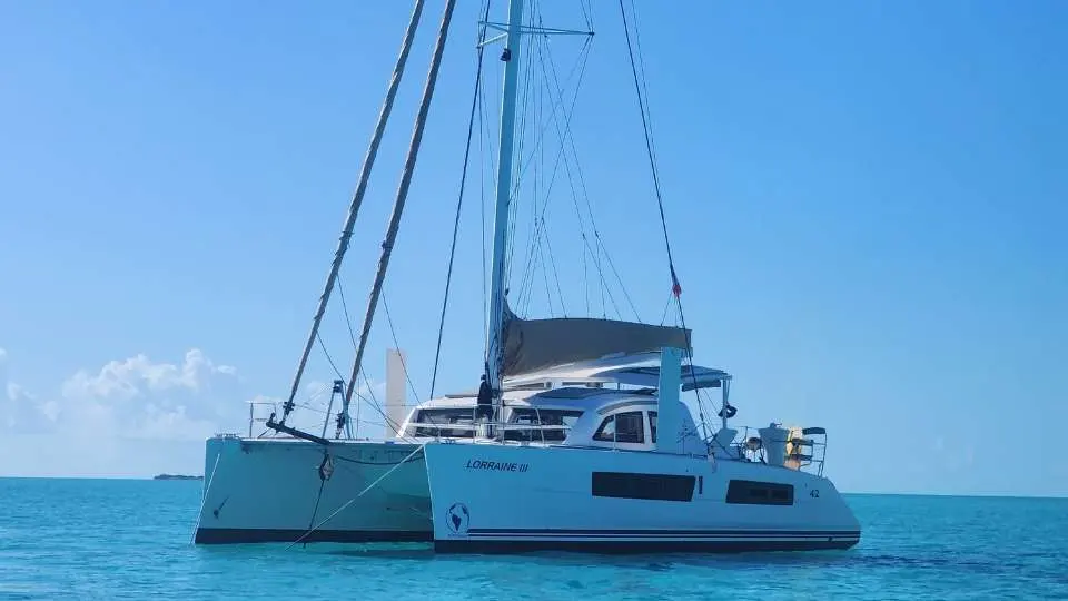 Catana 42 — Catamaran blanc photographié de profil sur une mer calme, voiles affalées.