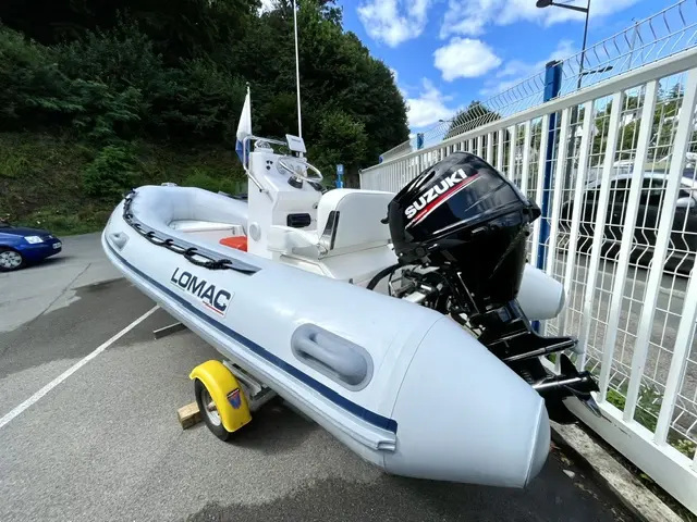 Lomac 400 Open — Bateau pneumatique blanc Lomac équipé d’un moteur hors-bord Suzuki, sur remorque.