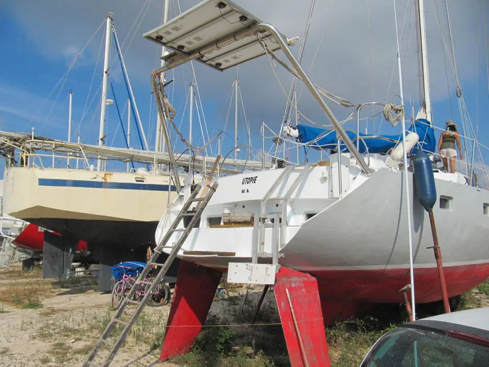 Metalu Swing 50 — Catamaran blanc à coques rouges stationné à terre, vu depuis l’arrière.