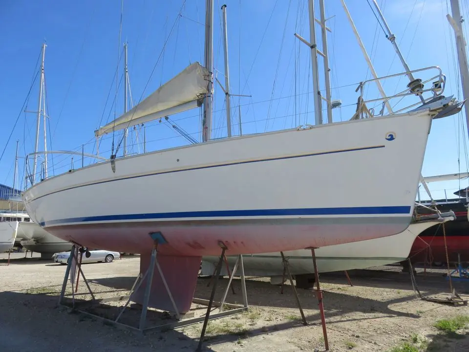 Beneteau Cyclades 43 — Voilier blanc à bande bleue photographié à terre, vu de trois quarts.