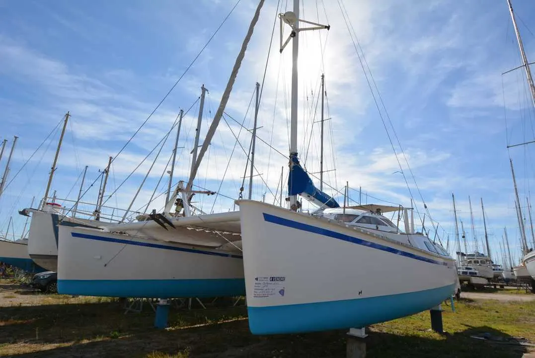 Outremer 40 — Catamaran blanc et bleu présenté à terre dans un chantier nautique.