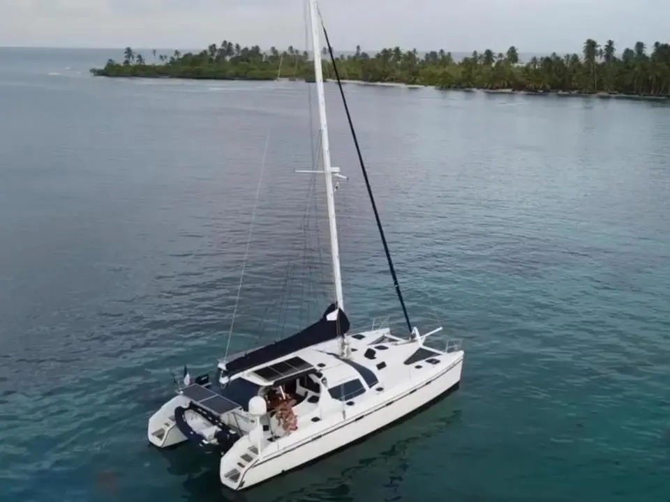 Alliaura Marine Privilege 465 — Catamaran blanc vu du ciel, au mouillage devant une île tropicale.