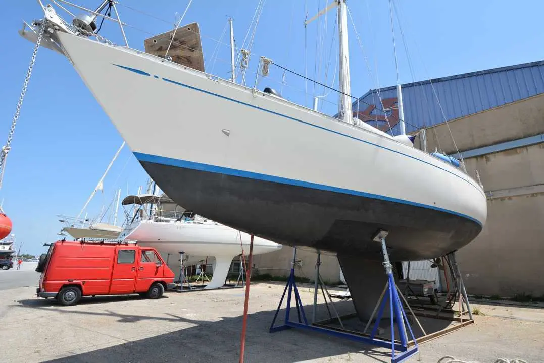 Nautor Swan Swan 53 — Voilier blanc et bleu posé sur bers dans un chantier naval.