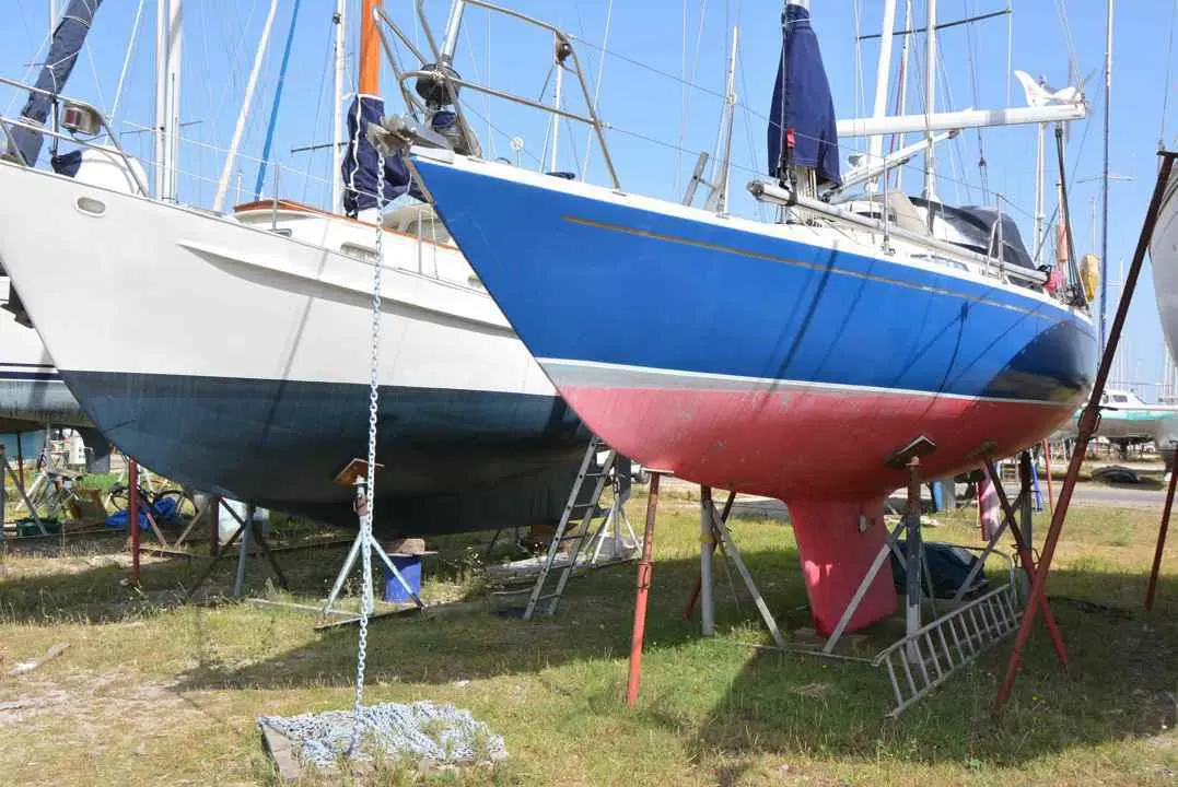 Albin Marine Ballad — Voilier bleu et rouge posé sur bers dans un chantier naval.