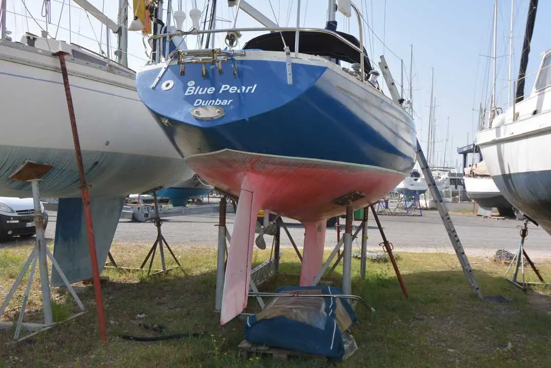 Albin Marine Ballad — Voilier bleu photographié à terre, entre deux autres bateaux.