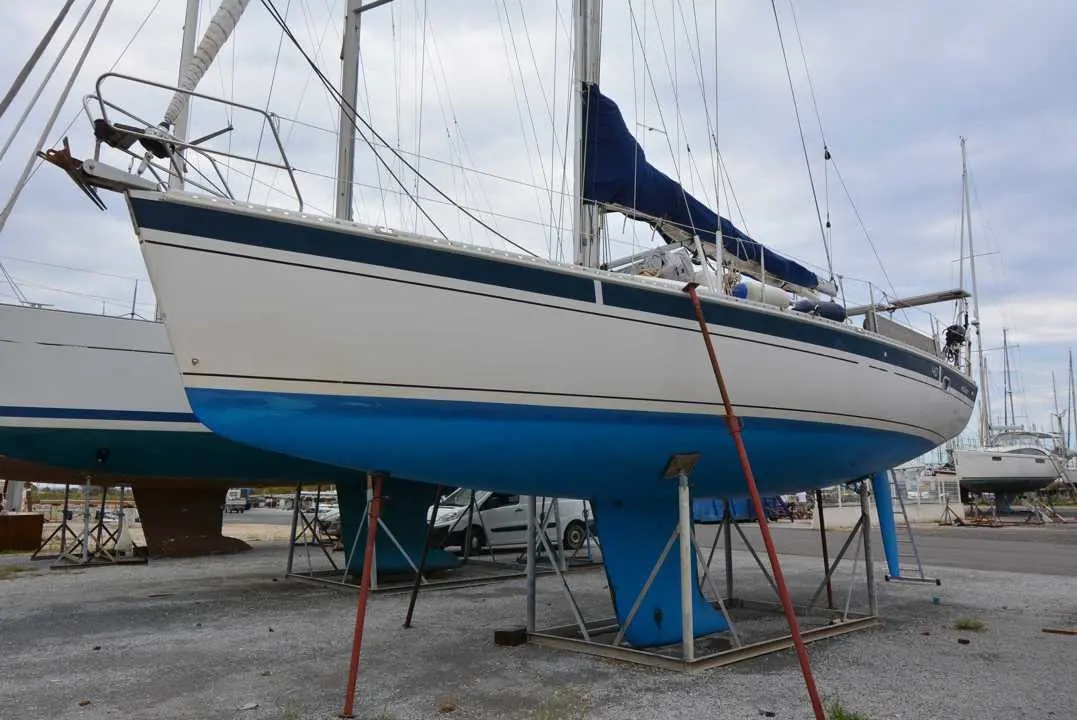 Elan 40 — Voilier à coque blanche et bleue posé sur bers dans un chantier naval.