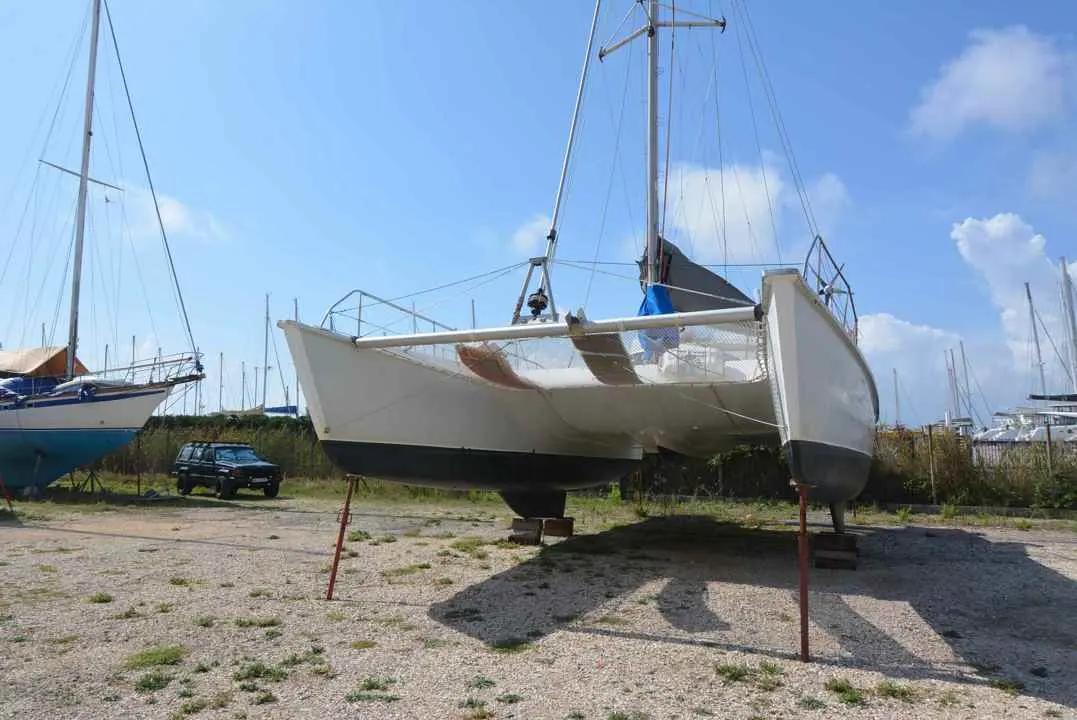 Fountaine Pajot Louisiane — Catamaran blanc à voile posé à terre dans un chantier nautique.