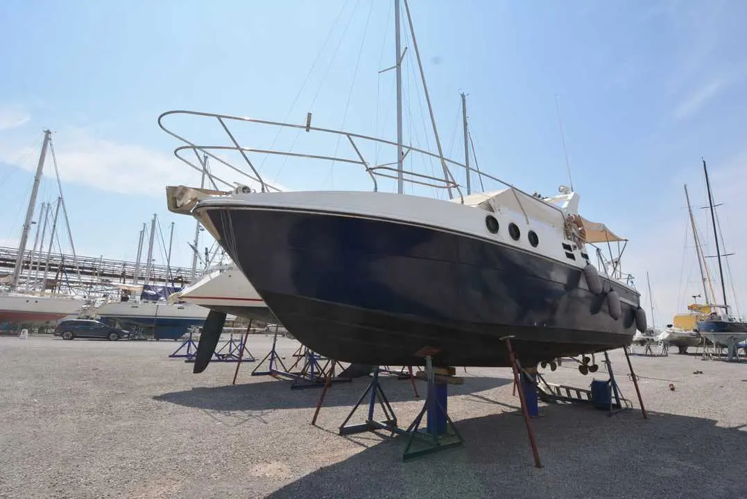 Azimut 32 — Bateau à moteur bleu et blanc présenté sur bers dans un port à sec.