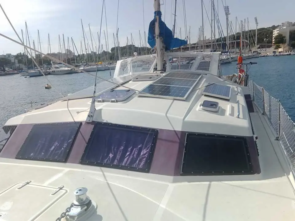 Prout Snowgoose 37 — Vue rapprochée du pont avant d’un catamaran amarré, avec panneaux solaires.