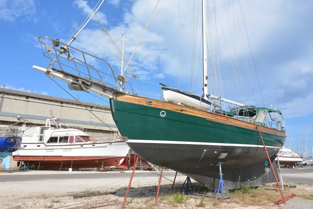 Hans Christian 43 Pilot House — Voilier à coque verte photographié à terre dans un chantier naval.