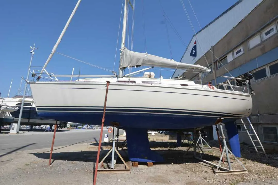 Hanse 312 — Voilier blanc à l’arrêt sur bers dans une zone technique extérieure.