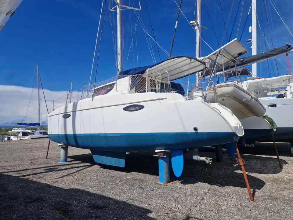 Fountaine Pajot Mahe 36 — Catamaran blanc et bleu posé à terre dans un chantier nautique.