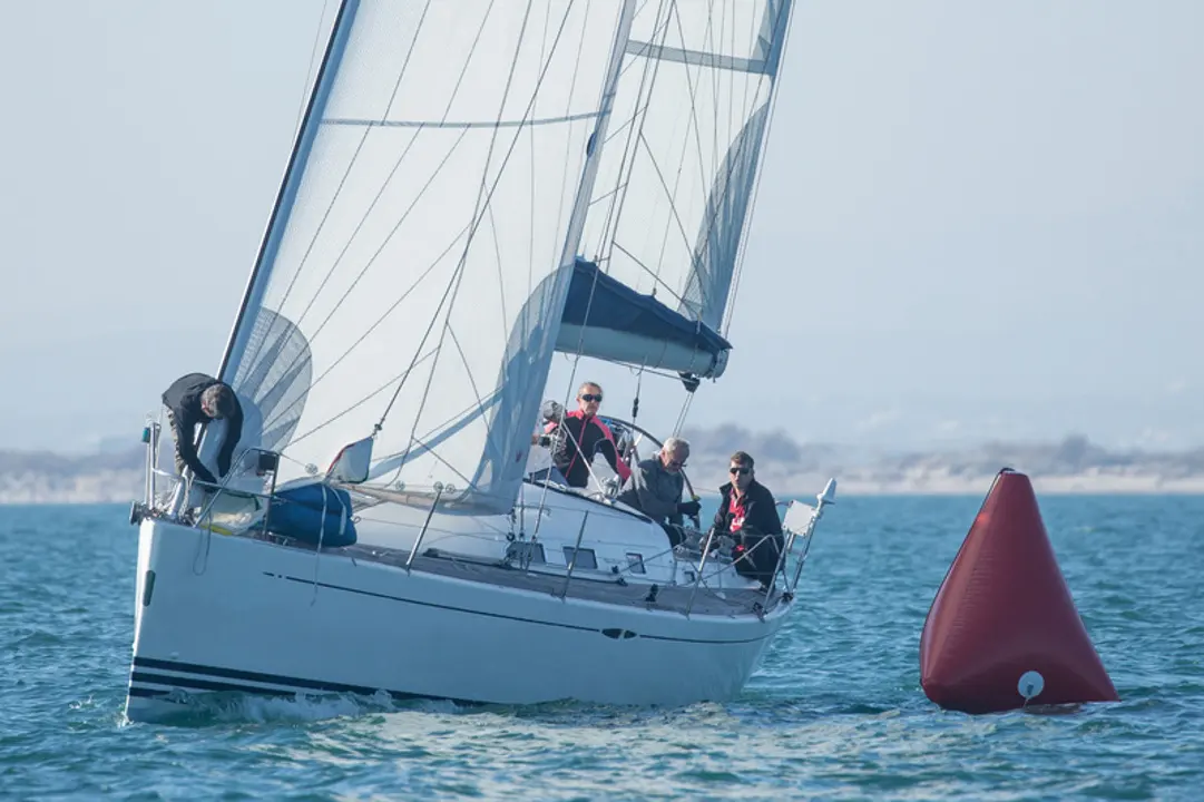 X-Yachts X-40 — Voilier naviguant au près avec plusieurs personnes à bord, près d'une bouée.