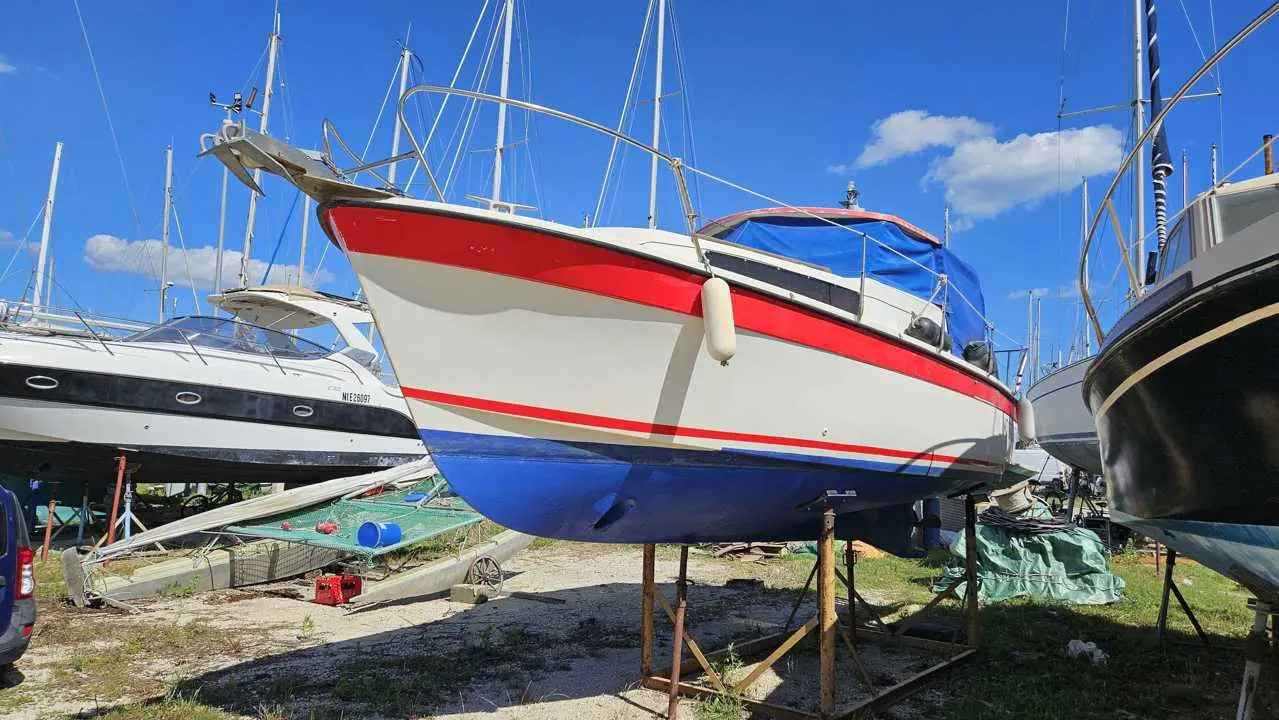 Bonum 25 — Voilier à coque blanche et rouge présenté sur bers dans un chantier naval.