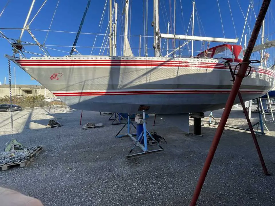 Alubat Ovni 37 — Voilier à sec sur bers, photographié de profil dans une zone de chantier.
