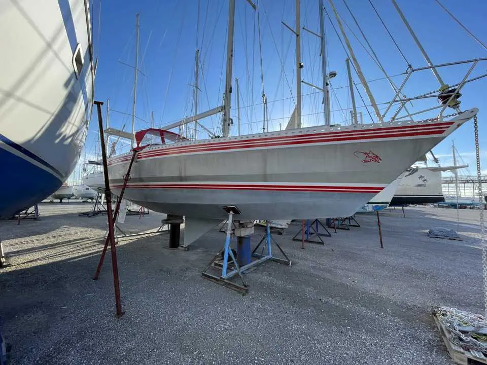 Alubat Ovni 37 — Voilier à coque blanche et liserés rouges, posé sur bers dans un chantier naval.