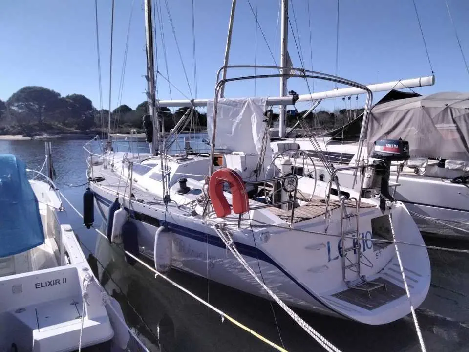 Pouvreau Rivage 39 — Voilier amarré vu de trois quarts arrière dans un port, entre d'autres bateaux.