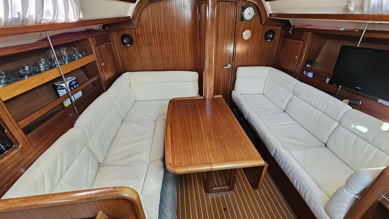Bavaria OCEAN 40 CC — Carré intérieur avec banquettes en cuir, table centrale et boiseries.