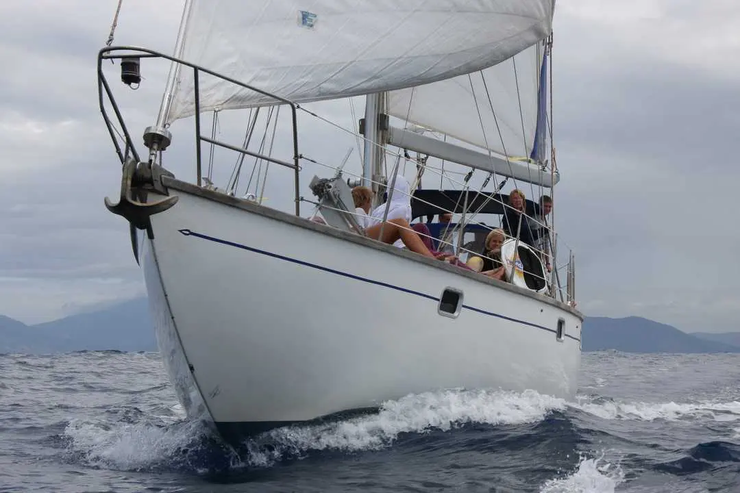 Bruce Roberts 45 Spray — Voilier blanc photographié de face en navigation, avec plusieurs personnes à bord.
