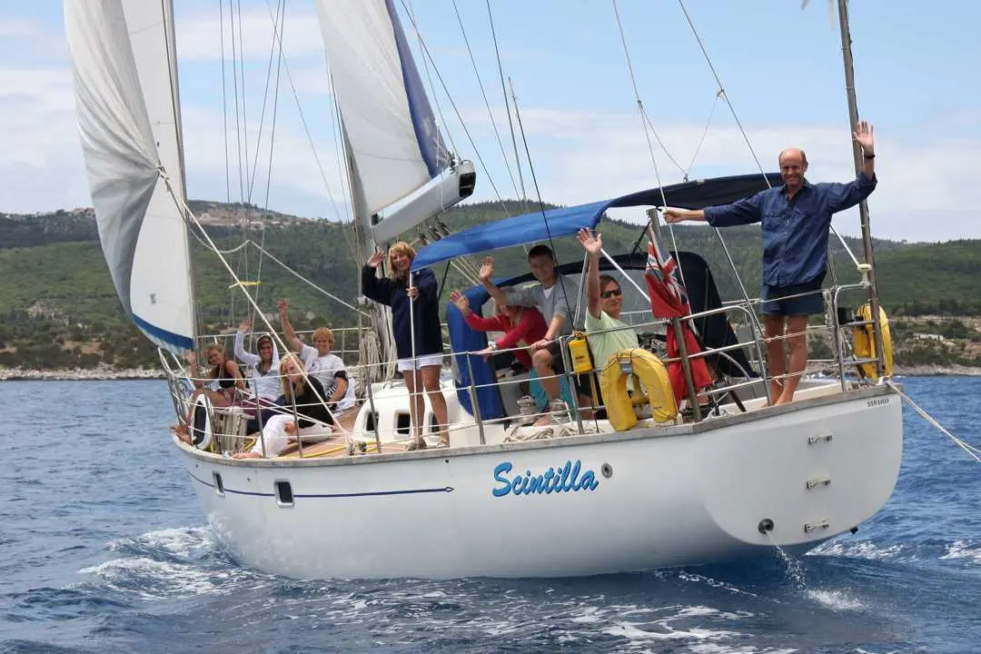 Bruce Roberts 45 Spray — Voilier blanc sous voiles, avec plusieurs personnes à bord, naviguant près des côtes.