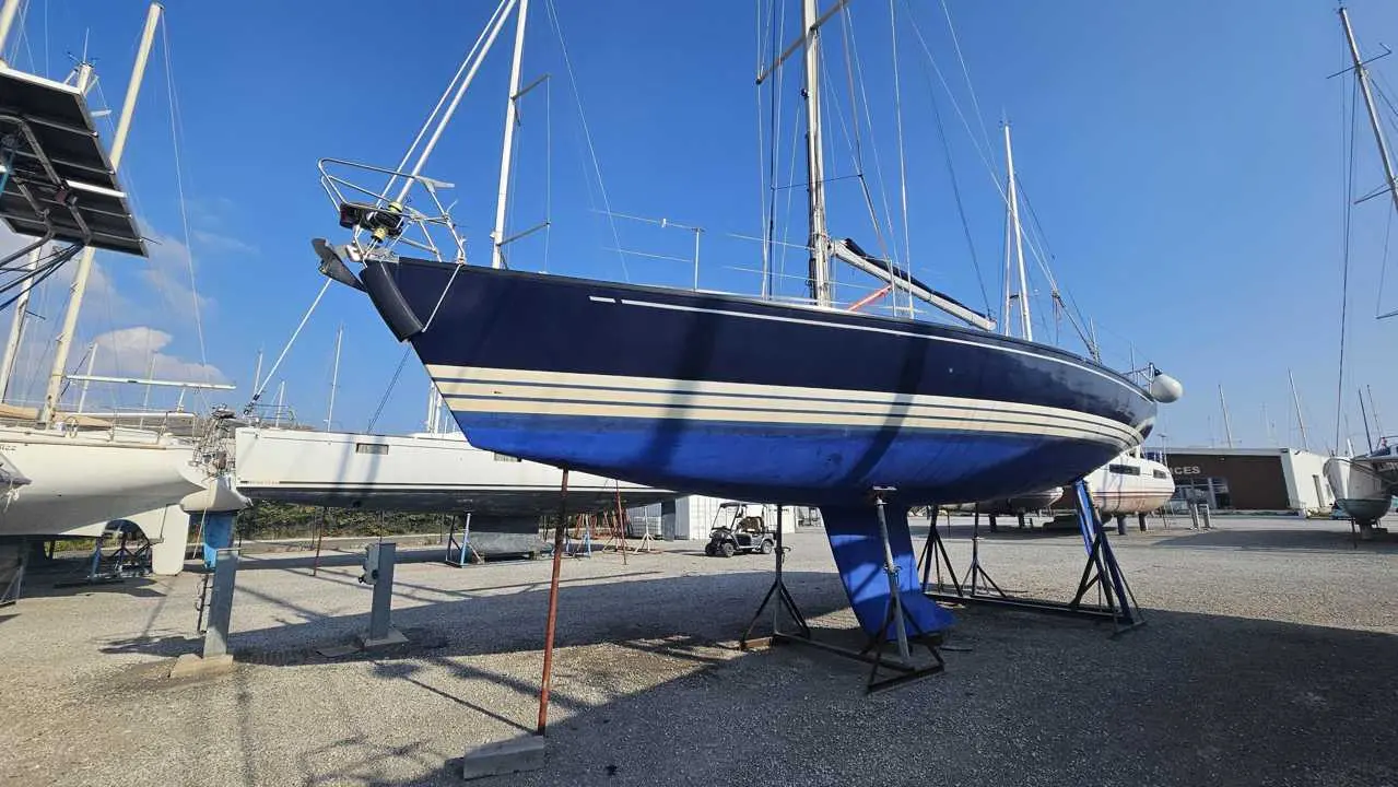X-Yachts X-412 — Voilier bleu et blanc présenté à terre sur bers dans un chantier naval.