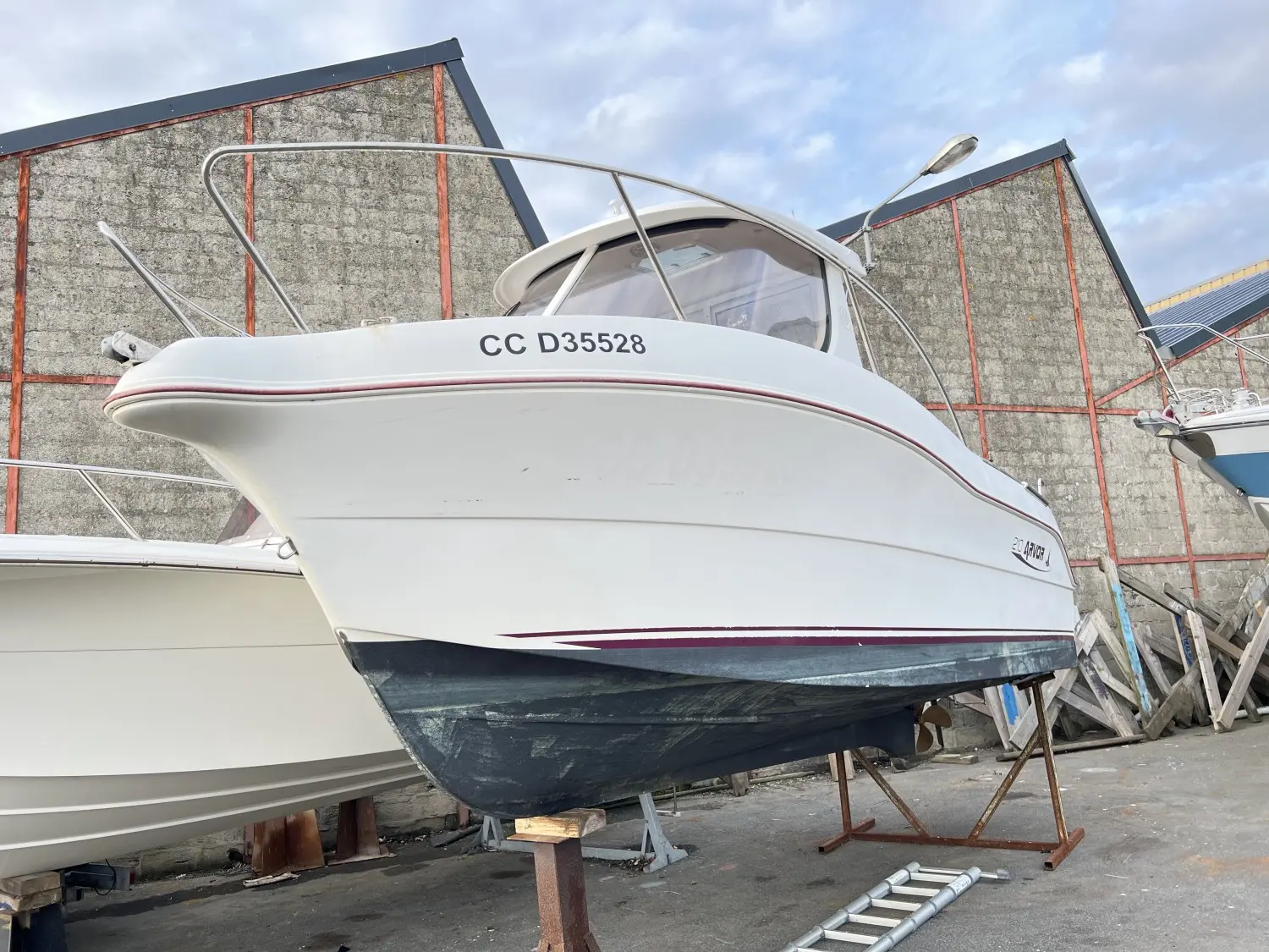 Arvor 210 — Bateau à cabine photographié à terre, vu de trois quarts avant.