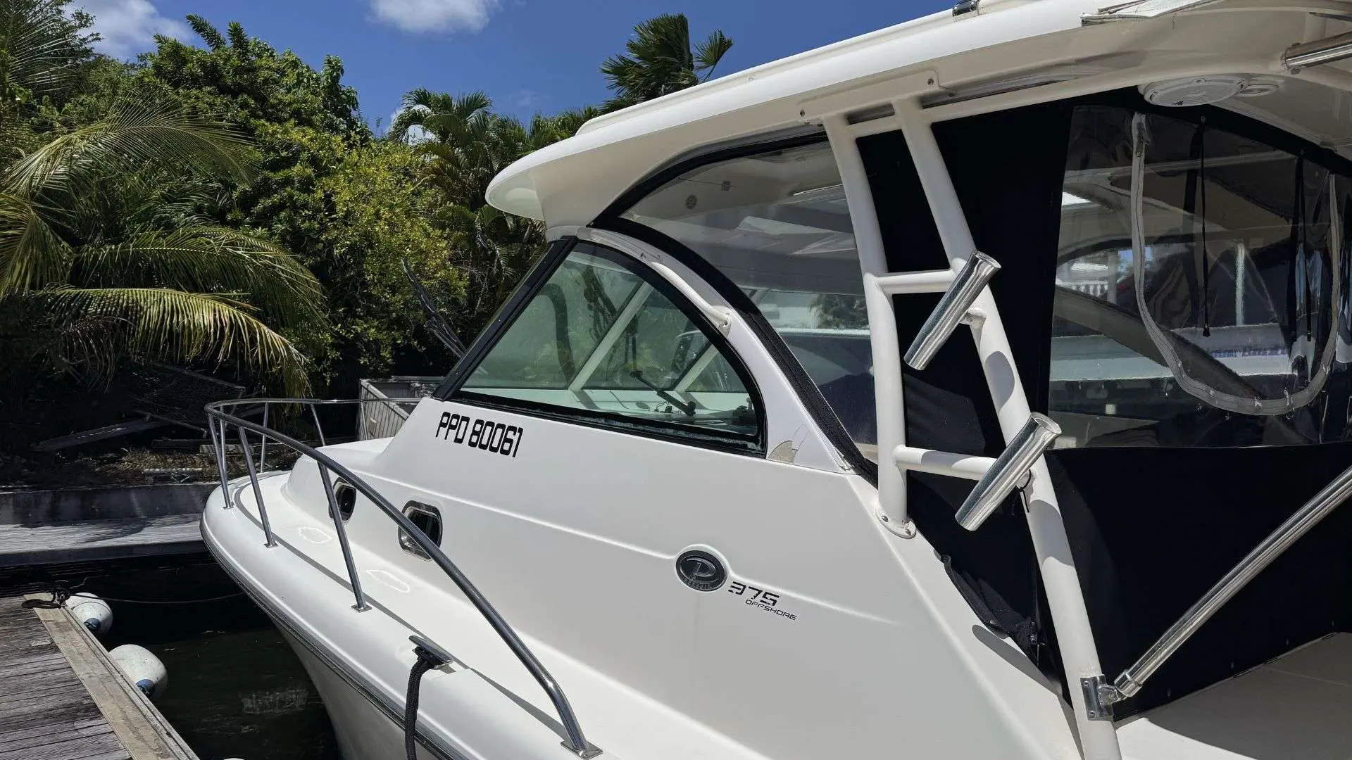 Pursuit OS 375 Offshore — Vue rapprochée de la cabine et du flanc d’un bateau blanc amarré au quai.