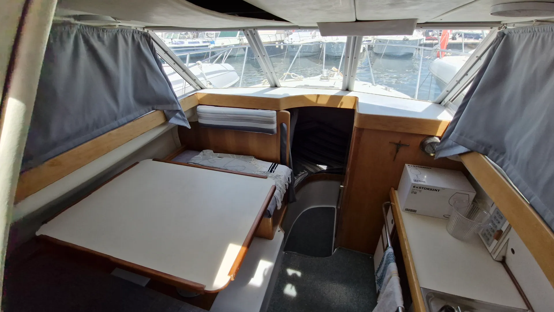 Eider Marine Sea Rover 7600 — Vue intérieure du carré avec table, banquettes et vue sur le pont avant.