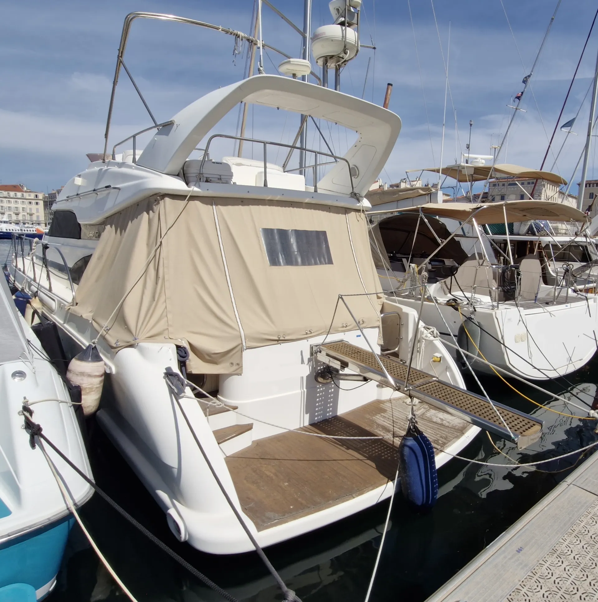 Garin 1550 — Bateau à moteur vu de l’arrière, amarré dans un port sous un taud beige.