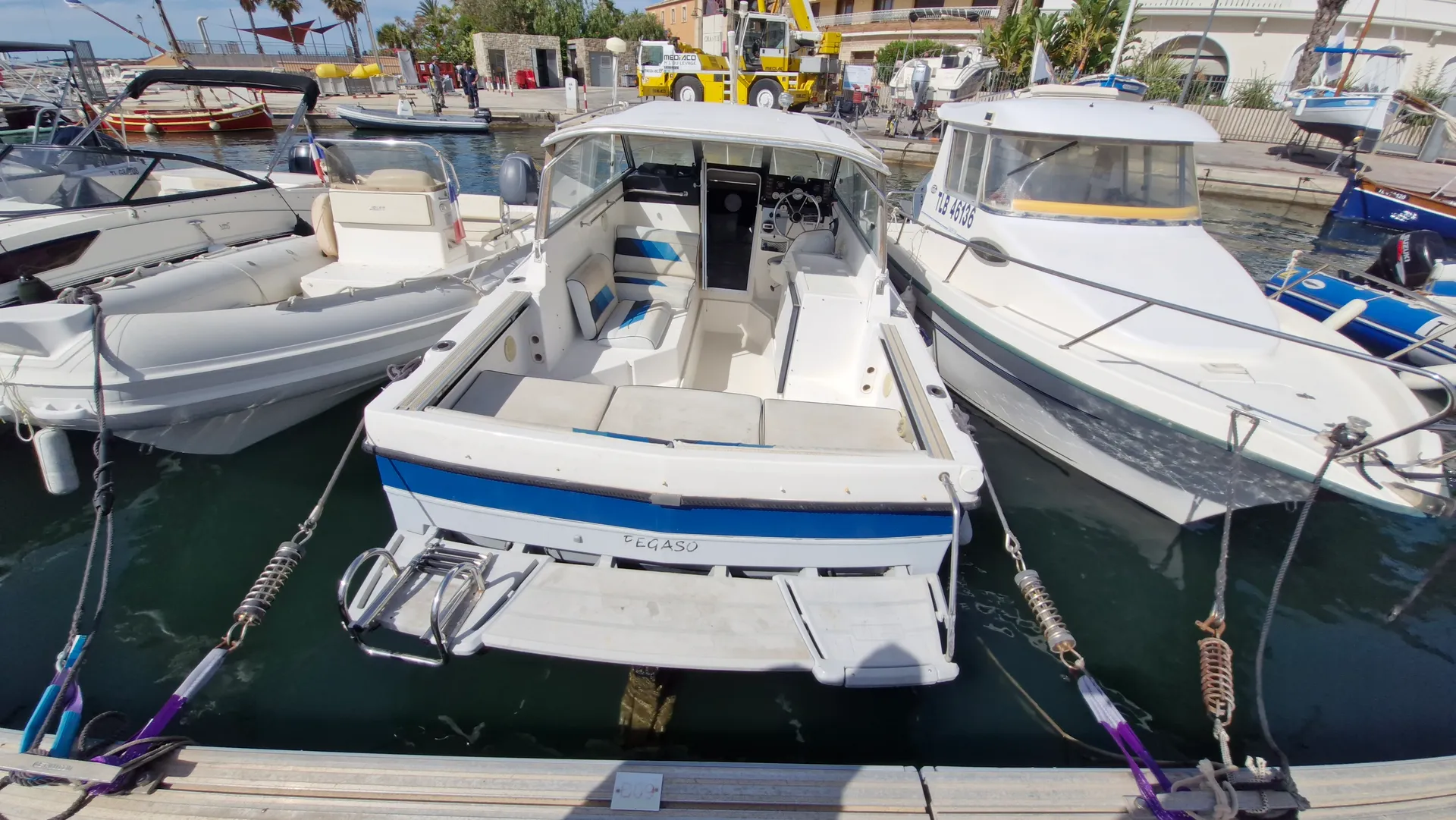 Bayliner Trophy 2159 — Bateau blanc et bleu amarré, vu de l’arrière dans un port.