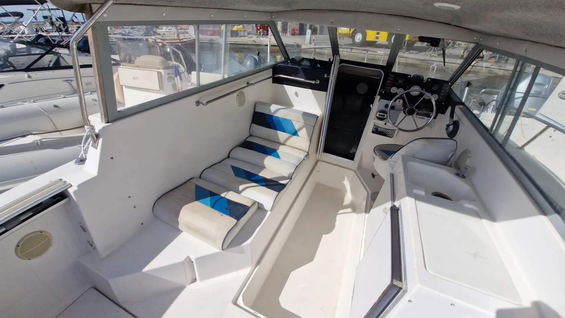 Bayliner Trophy 2159 — Vue intérieure du cockpit avec banquette, poste de pilotage et rangements.