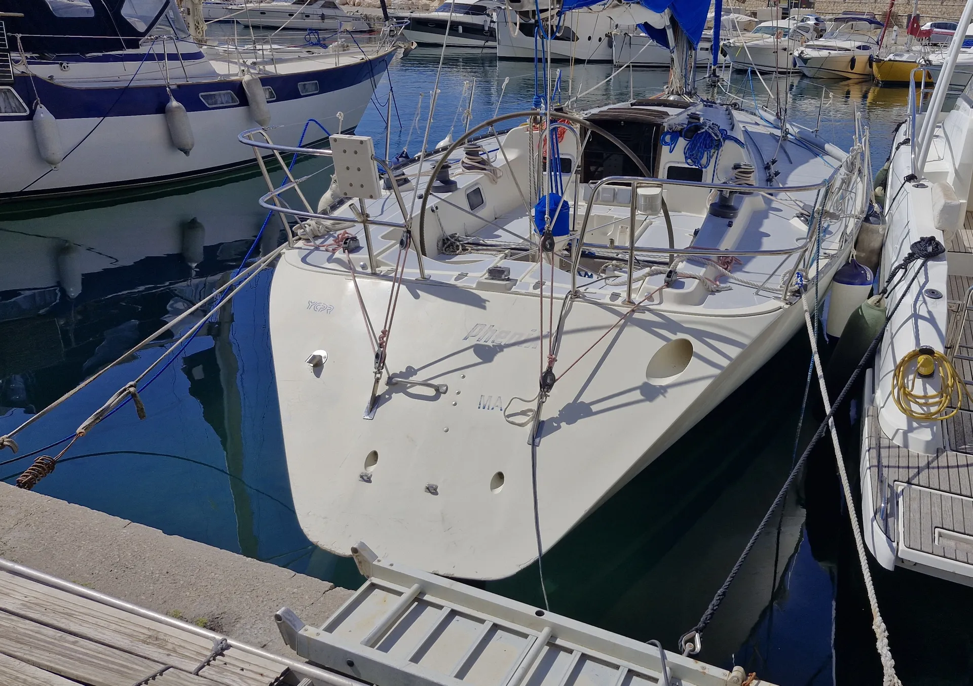 X-Yachts X-402 — Voilier blanc amarré dans une marina, vu de l’avant depuis le ponton.