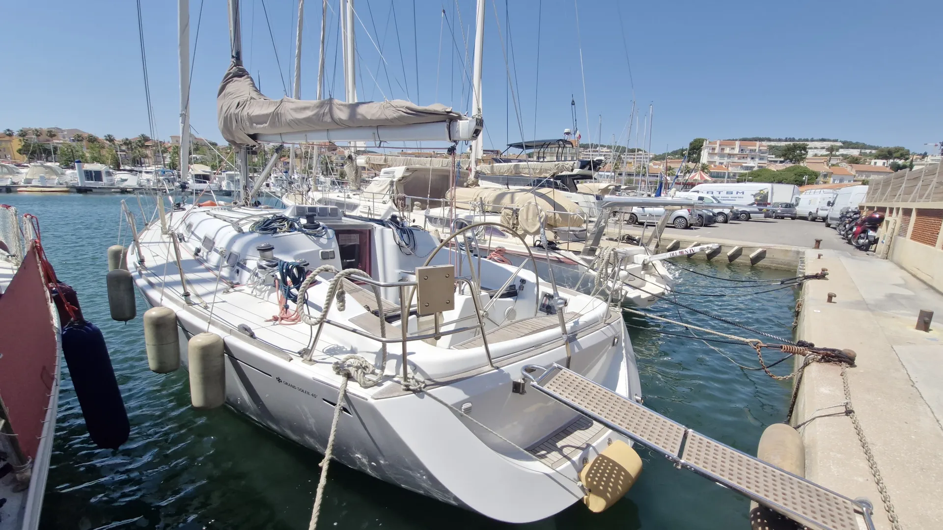 Grand Soleil 40 — Voilier blanc amarré dans un port, vu depuis l’arrière bâbord.