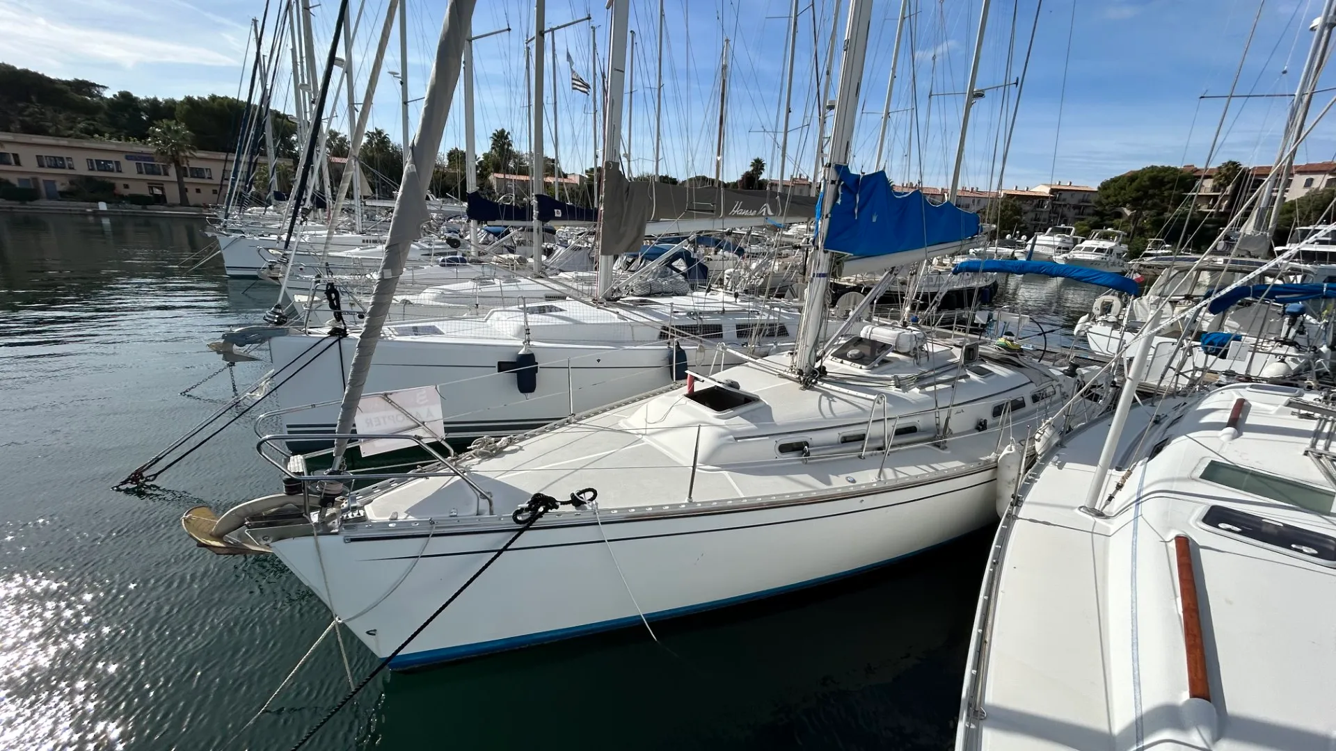 Hanse 371 — Voilier blanc amarré dans une marina, vu de trois quarts avant.