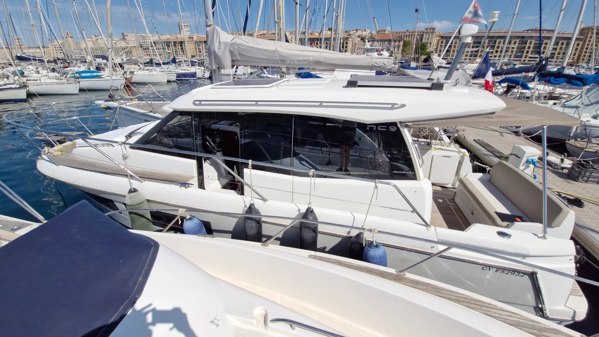 Jeanneau NC 9 — Bateau à moteur blanc amarré dans un port, photographié depuis une embarcation voisine.