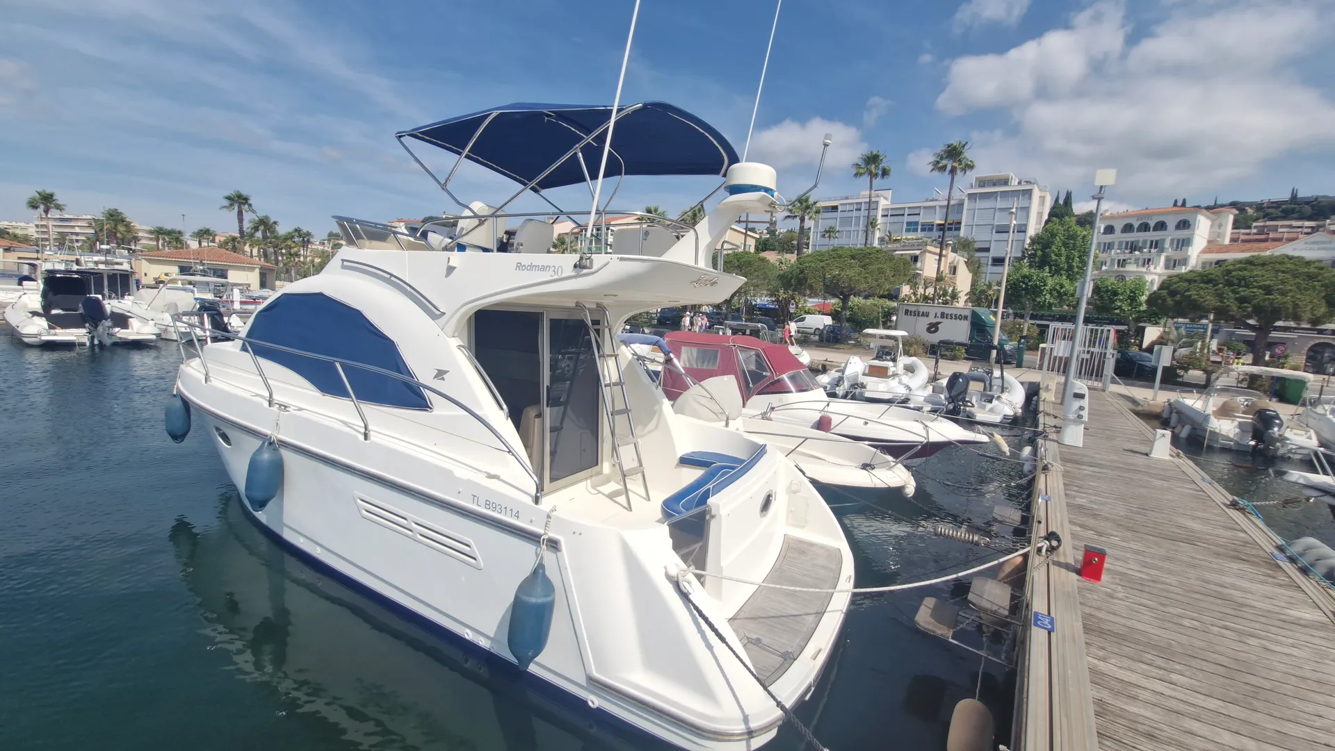 Rodman 30 — Bateau à moteur blanc amarré dans une marina, vu de trois quarts arrière.