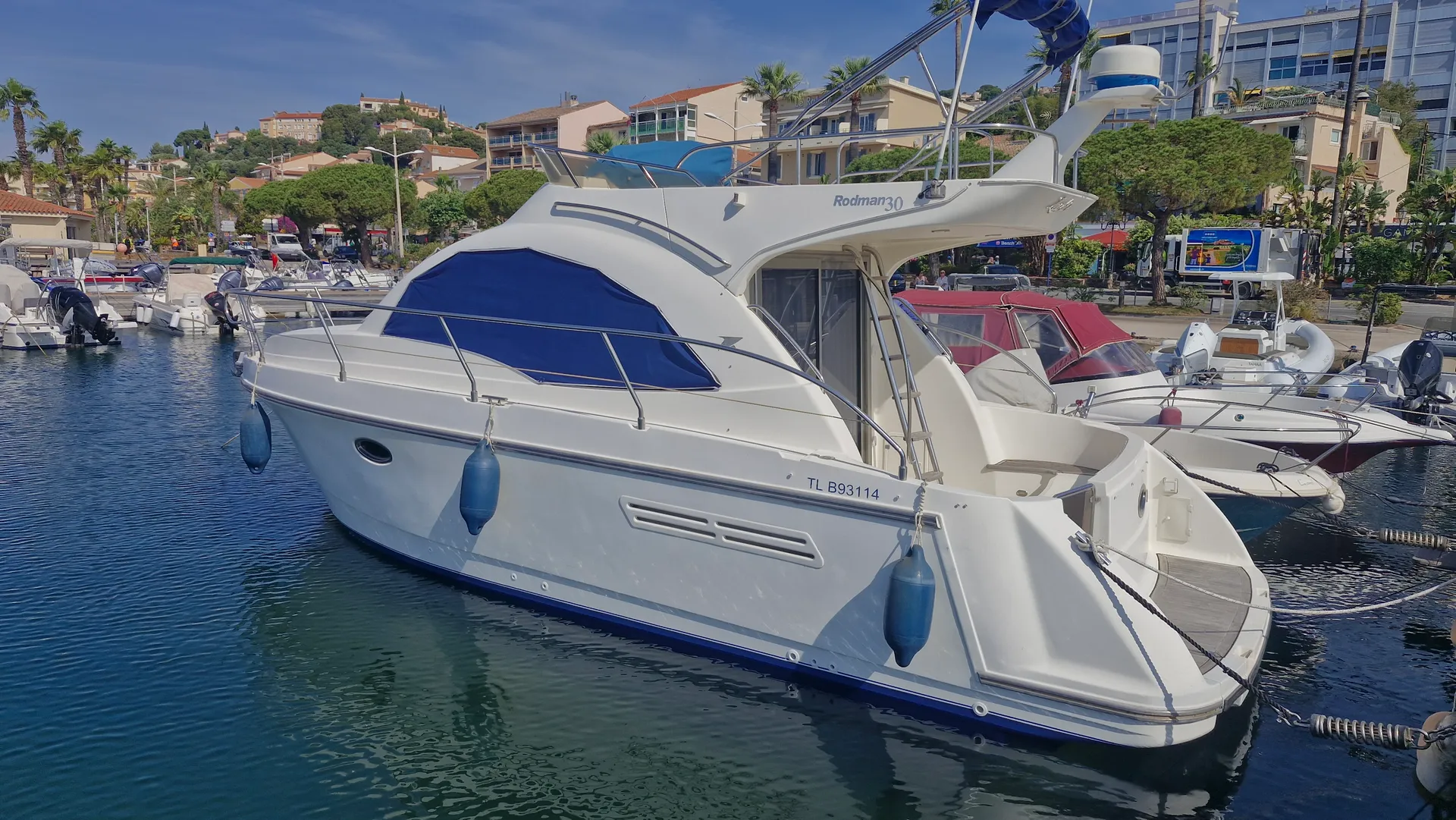 Rodman 30 — Bateau à moteur blanc amarré dans un port, vu de trois quarts arrière.
