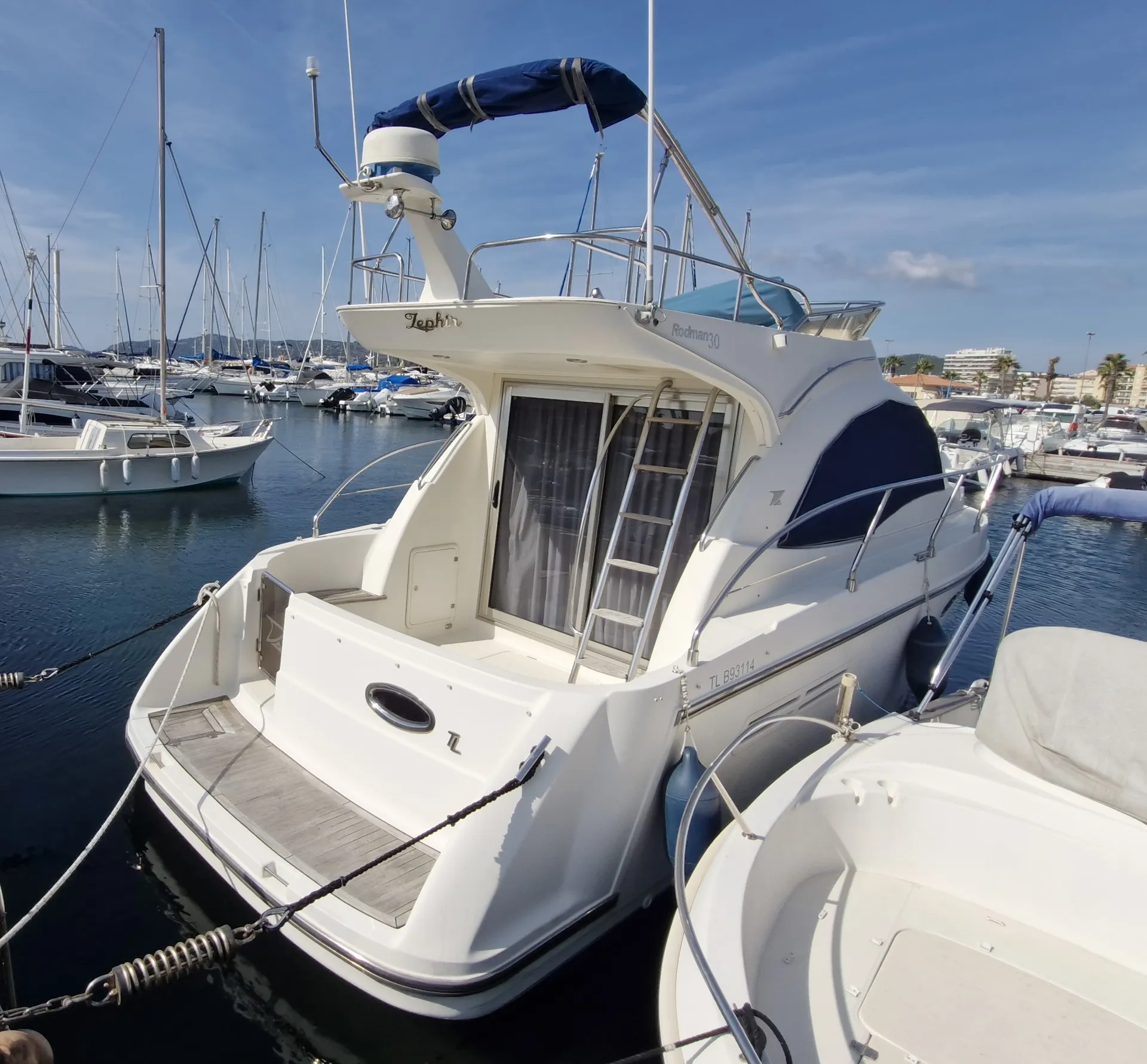 Rodman 30 — Vue arrière trois quarts d’un bateau à moteur amarré dans une marina.