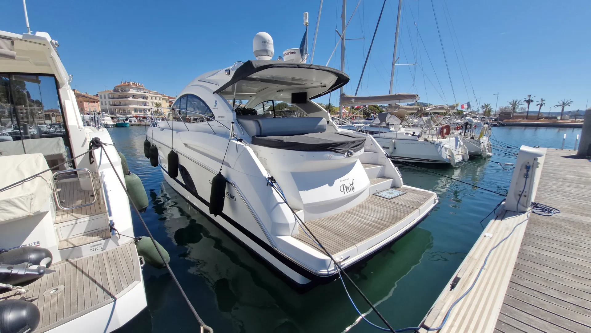 Beneteau GT 44 — Bateau à moteur blanc amarré dans un port, vu de trois quarts arrière.