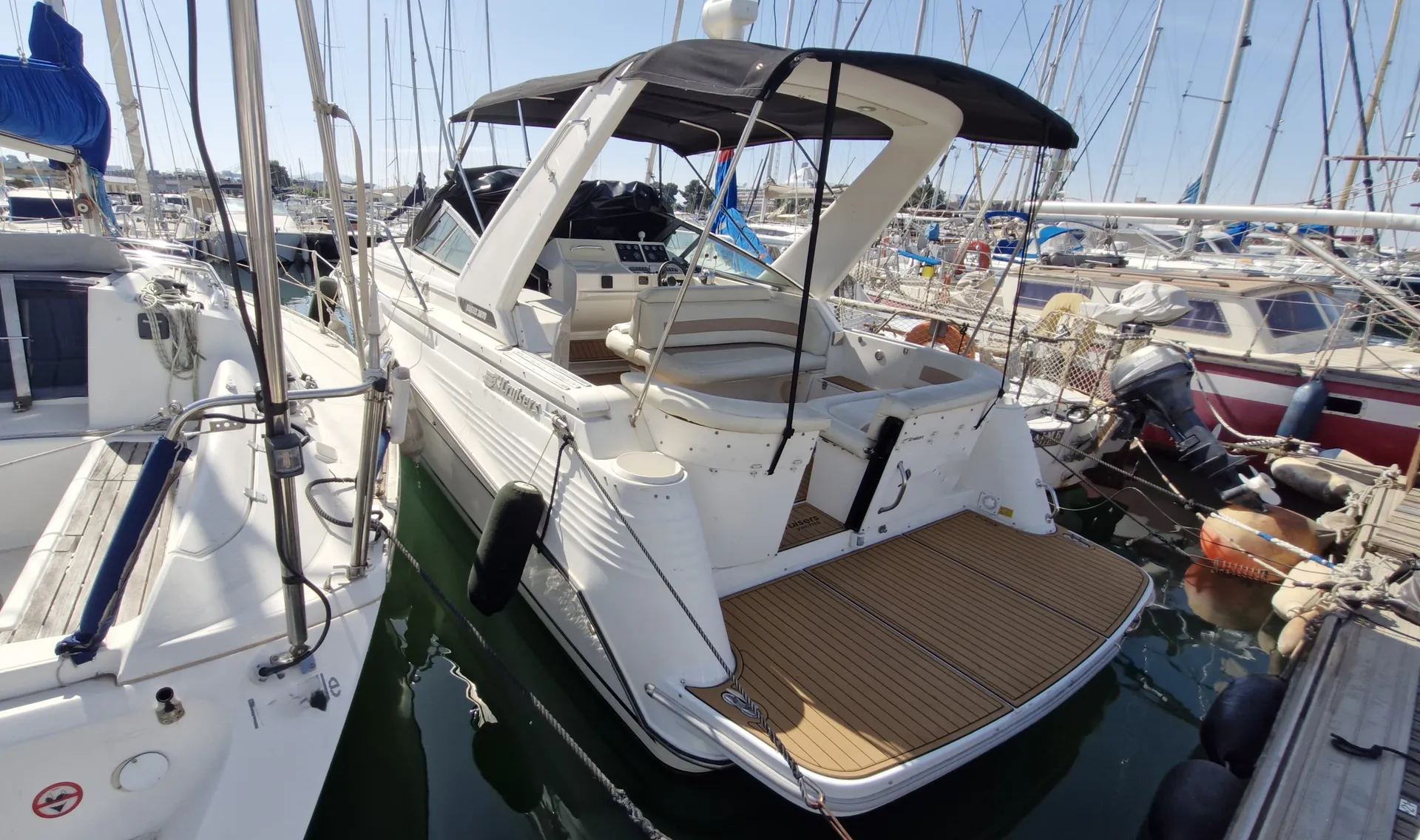 Cruisers Yachts 3070 Rogue — Bateau à moteur blanc vu de trois quarts arrière dans une marina.