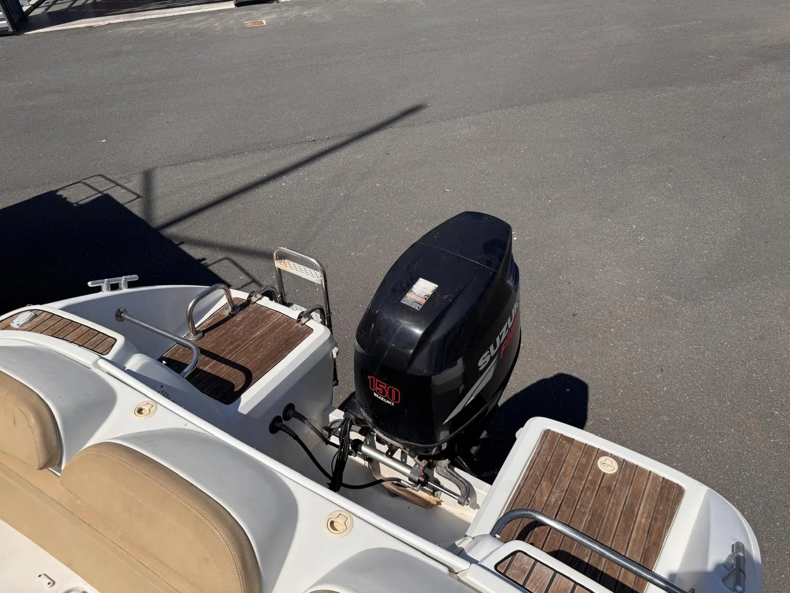 Beneteau Flyer 650 Cabrio — Vue rapprochée de la poupe et du moteur hors-bord d’un bateau.