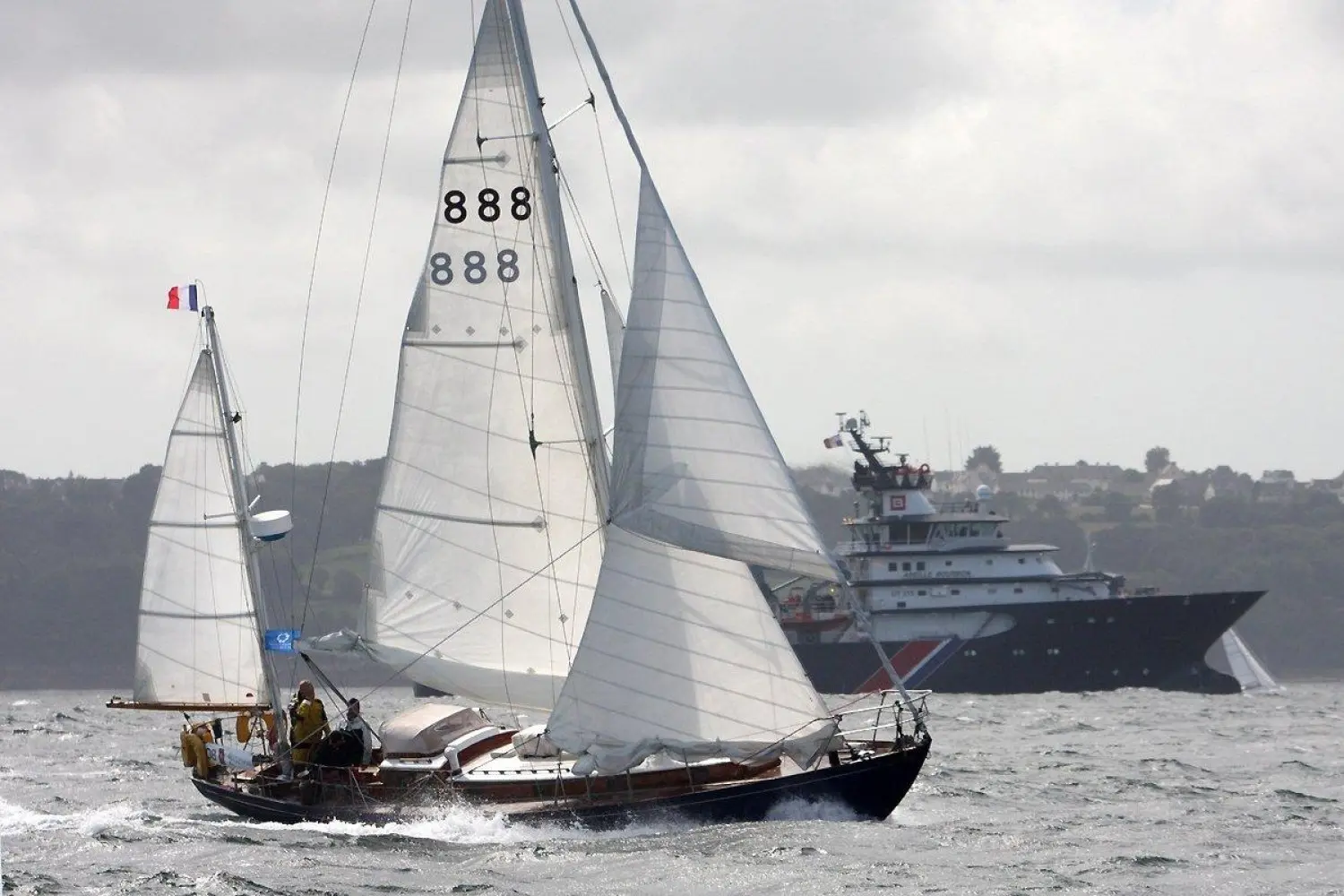 Arthur Robb Yawl Bermudien — Voilier classique au large, toutes voiles hissées devant un navire.