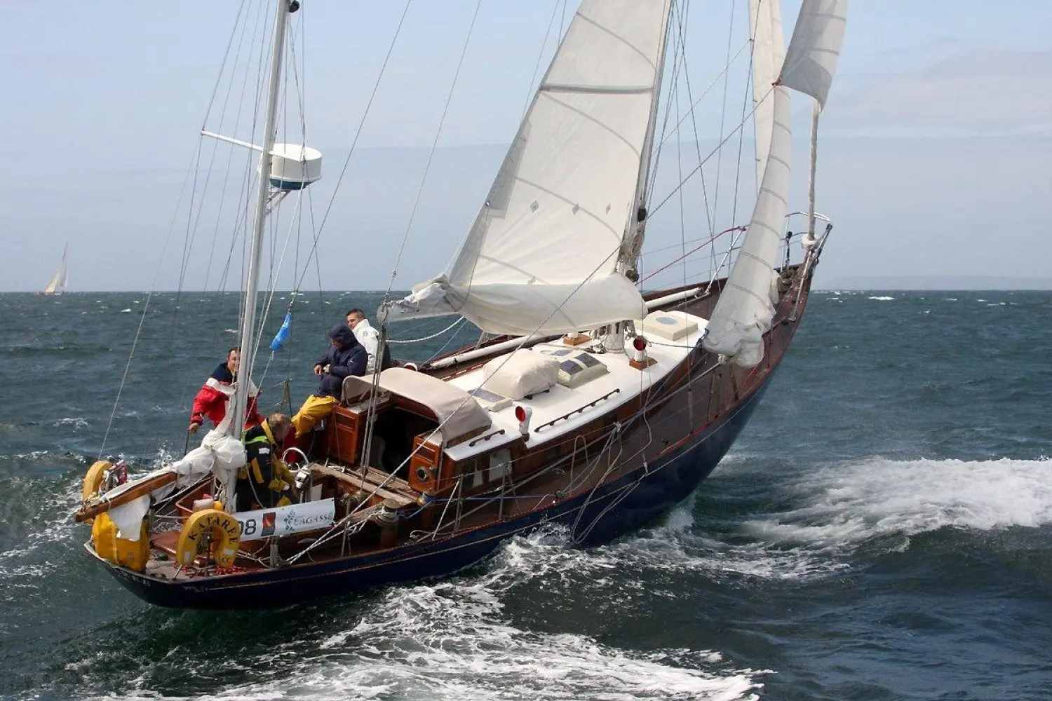 Arthur Robb Yawl Bermudien — Voilier classique à deux mâts naviguant au large, avec plusieurs personnes à bord.