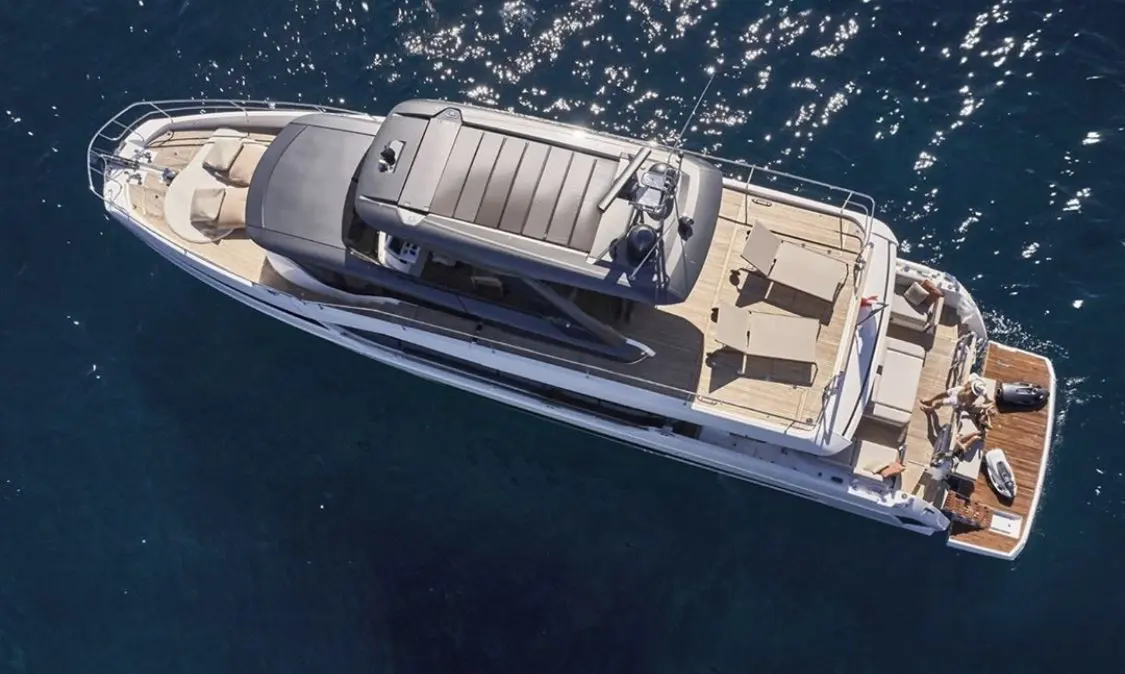 Prestige Yachts X70 — Vue aérienne d’un yacht blanc naviguant sur une mer bleu foncé.