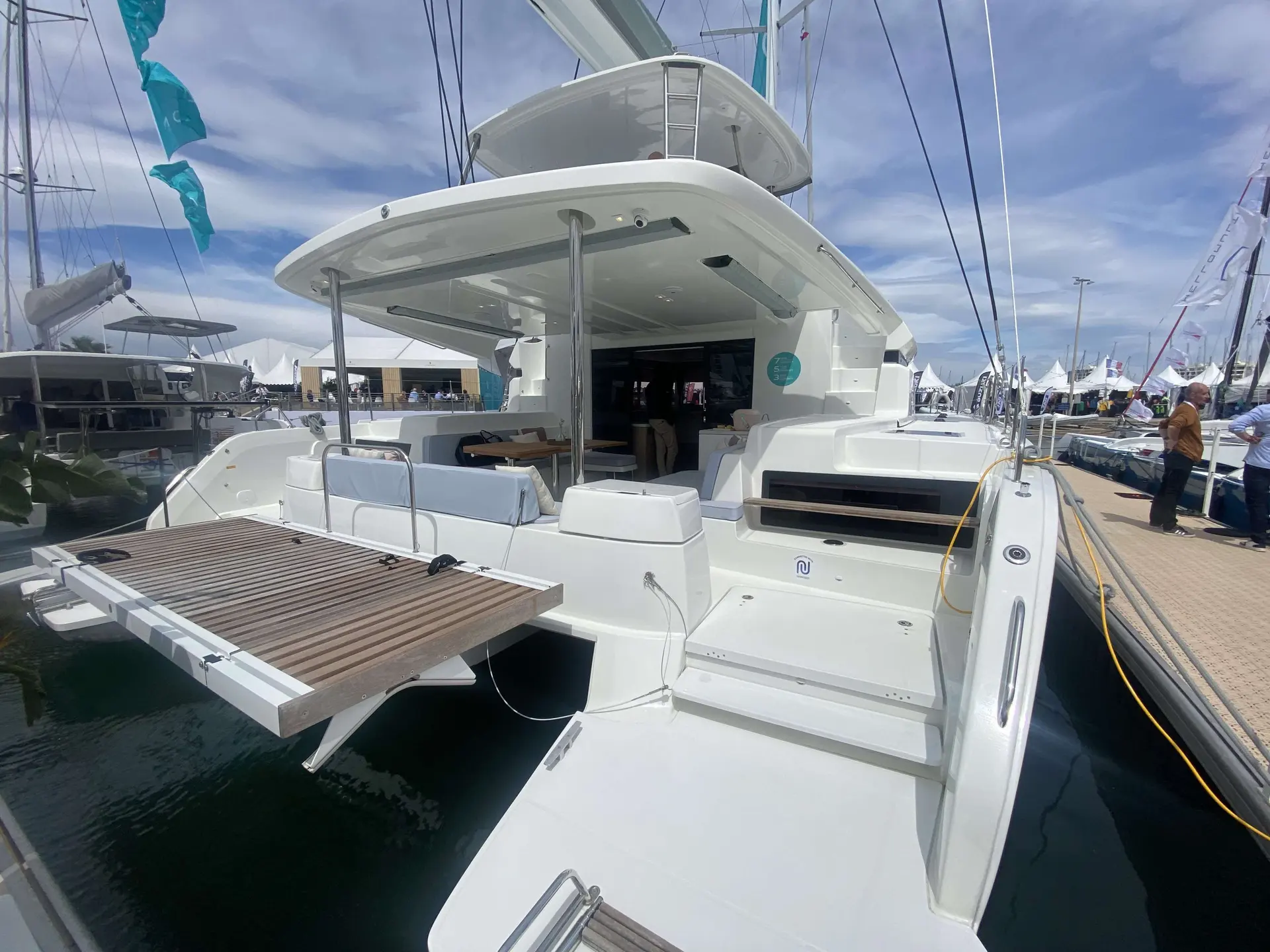 Lagoon 51 — Vue arrière trois quarts d’un catamaran blanc amarré à un ponton.