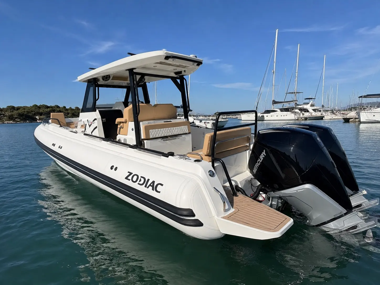 Zodiac X9cc — Bateau semi-rigide blanc vu de trois quarts arrière dans une marina.