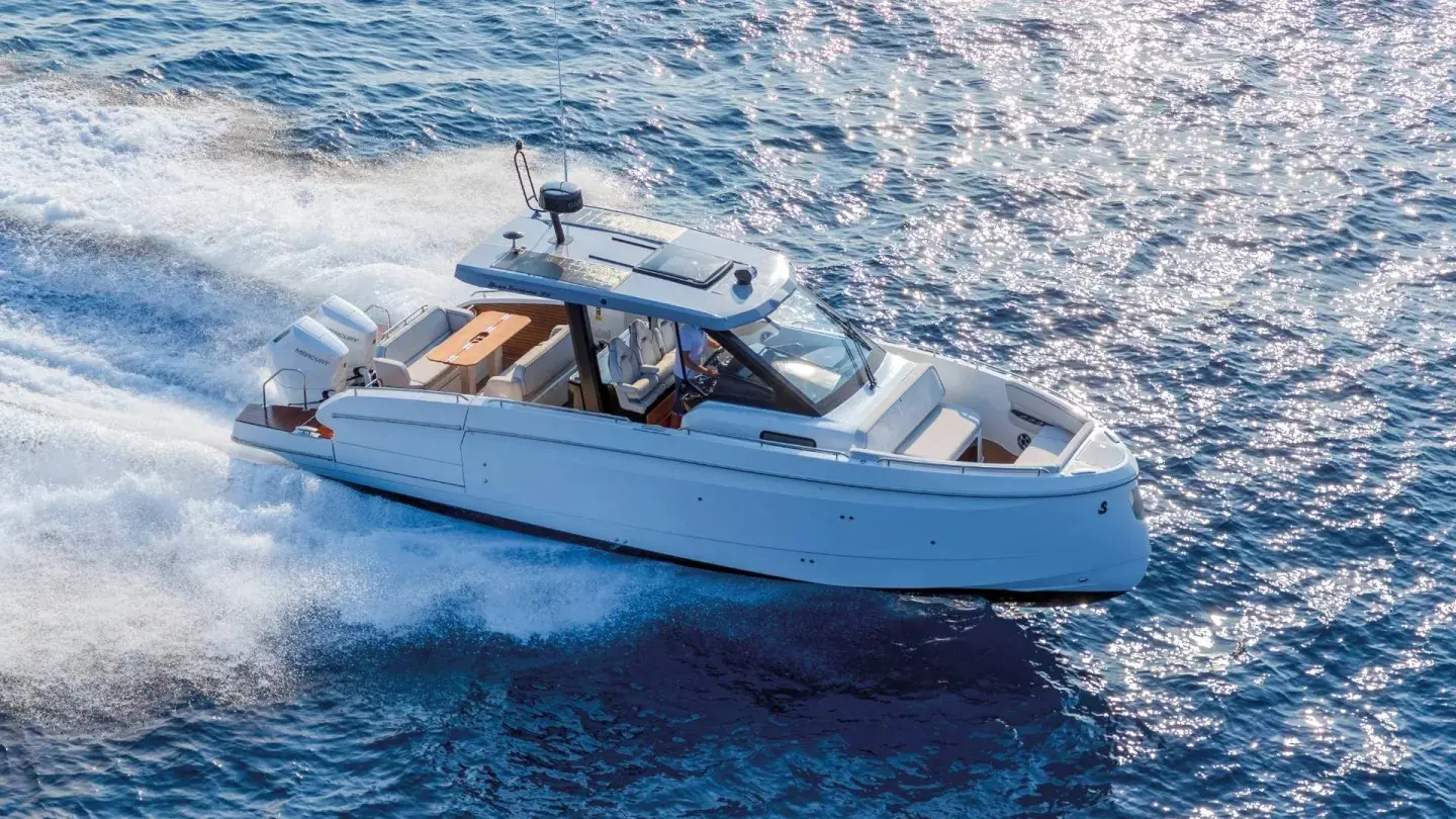 Beneteau Gran Turismo 35 — Bateau à moteur vu de trois quarts, naviguant à vive allure sur une mer scintillante.
